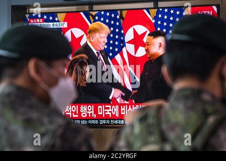 Soldaten sehen TV-Nachrichten, die Donald Trump und Kim Jung-UN während einer Pressekonferenz im Seoul-Sender zeigen.Nordkorea zerstörte Verbindungsbüro mit Südkorea am 16. Juni geteilt. Stockfoto