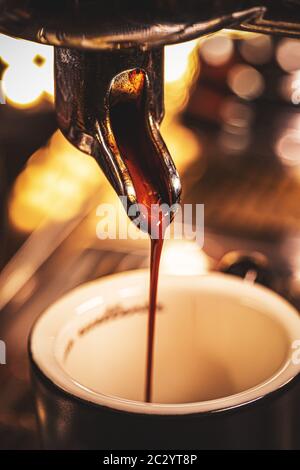 Espresso fließt aus der Kaffeemaschine. Stockfoto