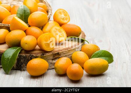 Haufen von Kumquat-Früchten, chinesische Mandarinen, auf Holztisch. Stockfoto