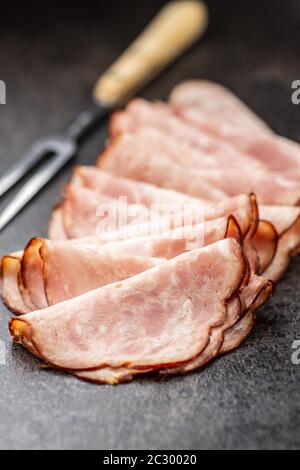 Geschnittene Salamiwurst. Geräucherter Schinken auf dem alten Küchentisch. Stockfoto