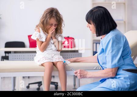 Kleines Mädchen besuchen alte Frau Doktor Stockfoto