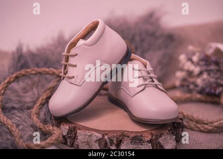 Vintage-Bild von Kinderschuhen. Kinder weiße Lederschuhe auf alten rustikalen Holzhintergrund. Stockfoto