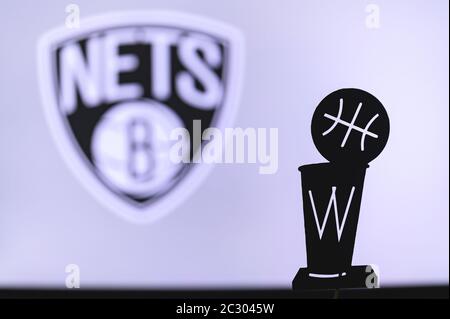 NEW YORK, USA, 18. JUN 2020: Brooklyn Nets Basketball Club auf dem weißen Bildschirm. Silhouette der NBA-Trophäe im Vordergrund. Stockfoto