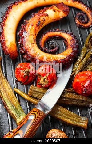 Gegrillter Tintenfisch mit geröstetem Gemüse in Grillpfanne. Köstliche gegrillte Meeresfrüchte Stockfoto