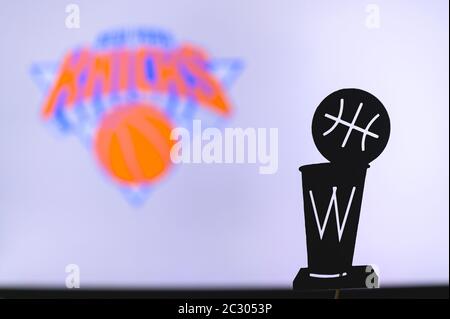 NEW YORK, USA, 18. JUN 2020: New York Knicks Basketball Club auf der weißen Leinwand. Silhouette der NBA-Trophäe im Vordergrund. Stockfoto