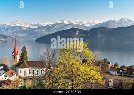 Urlaubsziel am Vierwaldstättersee mit der Pfarrkirche St. Maria hinter den verschneiten Alpen, Weggis, Kanton Luzern, Schweiz Stockfoto