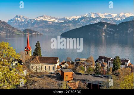 Urlaubsziel am Vierwaldstättersee mit der Pfarrkirche St. Maria hinter den verschneiten Alpen, Weggis, Kanton Luzern, Schweiz Stockfoto