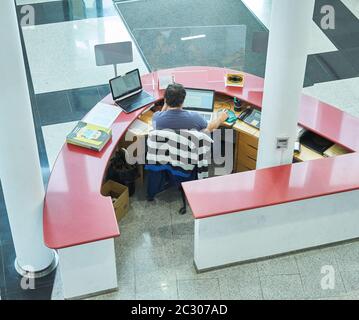Ein Hotelrezeptionist, der im Urlaub arbeitet. Reservierungskonzept. Stockfoto