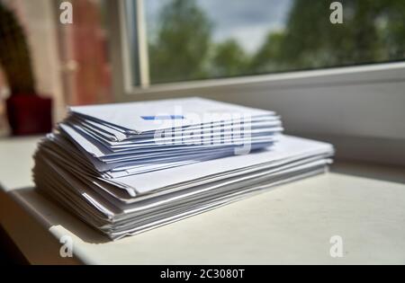 Stapel von Umschlägen in der Nähe des Fensters zu Hause platziert Stockfoto