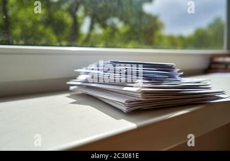 Stapel von Umschlägen in der Nähe des Fensters Stockfoto