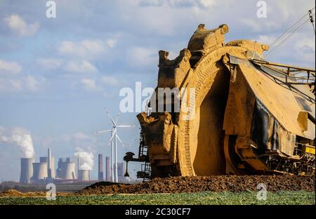Schaufelradbagger Radbagger im RWE Tagebau Garzweiler gräbt am Abrissrand bei Keyenberg, dahinter ein Wind Stockfoto