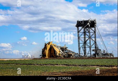 Schaufelradbagger Radbagger im RWE Tagebau Garzweiler gräbt am Abrissrand bei Keyenberg, dahinter ein Wind Stockfoto