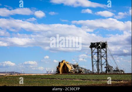 Schaufelradbagger Radbagger im RWE Tagebau Garzweiler gräbt am Abrissrand bei Keyenberg, dahinter ein Wind Stockfoto