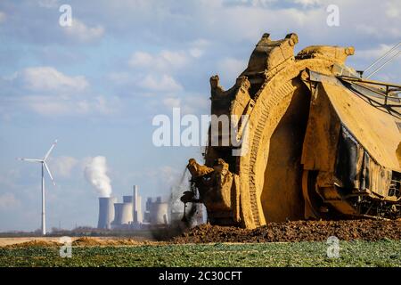 Schaufelradbagger Radbagger im RWE Tagebau Garzweiler gräbt am Abrissrand bei Keyenberg, dahinter ein Wind Stockfoto