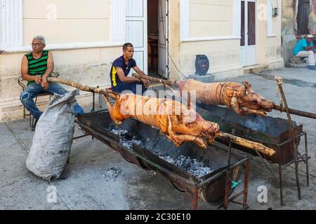 Schweinbraten in einer Fußgängerzone des Stadtzentrums, um anschließend Fleischportionen an die Öffentlichkeit, Manzanillo, Kuba, zu verkaufen Stockfoto