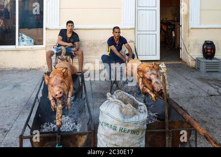 Schweinbraten in einer Fußgängerzone des Stadtzentrums, um anschließend Fleischportionen an die Öffentlichkeit, Manzanillo, Kuba, zu verkaufen Stockfoto