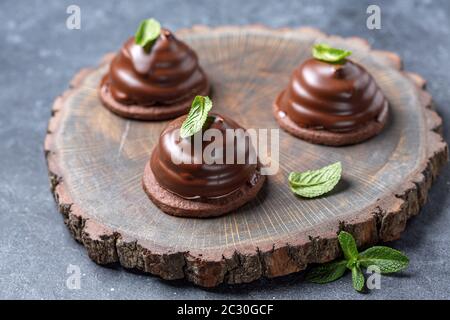 Mini-Schokoladen-Kuchen mit grünen Minzblättern. Stockfoto