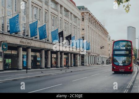 London, Großbritannien - 13. Juni 2020: Fassade des geschlossenen Heals Flagship Store in Tottenham Court Road, London, Bus fährt vorbei auf einer leeren Straße, Bewegung verschwimmen. Stockfoto