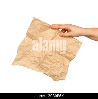 Die Hand hält ein zerknittertes braunes Blatt Pergamentpapier, das Motiv ist auf weißem Grund isoliert Stockfoto