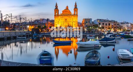 Blick auf den Hafen von Valletta mit Yachten und Fischerbooten, Msida Parish Church of Saint Joseph bei Sonnenuntergang, Malta Stockfoto