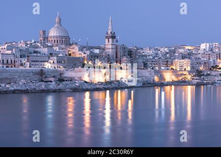 Mystisches Valletta mit Kirchen unserer Lieben Frau vom Berg Karmel und St. Paul's Anglikan Pro-Kathedrale bei Sonnenuntergang, wie aus Sliema, Valletta, Malta Stockfoto