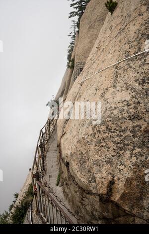 Steinerne Stufen Schnitt auf einer Seite eines Berges Rock, die zu der gefährlichen und gefährlichen Plank Spaziergang Trail, für den Zugang der Öffentlichkeit wegen schlechten Wetters condi geschlossen Stockfoto