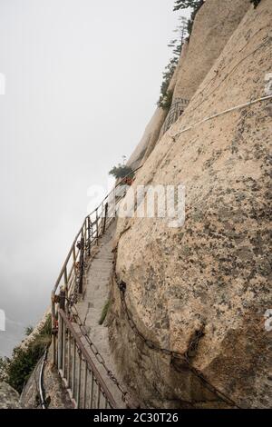 Steinerne Stufen Schnitt auf einer Seite eines Berges Rock, die zu der gefährlichen und gefährlichen Plank Spaziergang Trail, für den Zugang der Öffentlichkeit wegen schlechten Wetters condi geschlossen Stockfoto