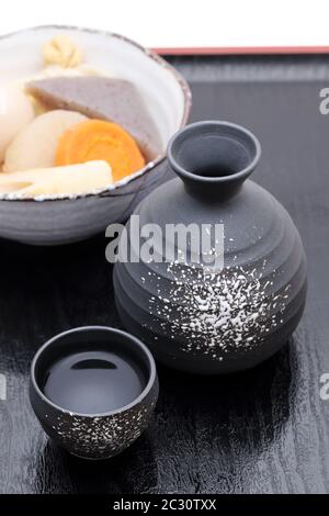 Traditionelle japanische Sake Becher und Flaschen mit Oden auf Fach Stockfoto