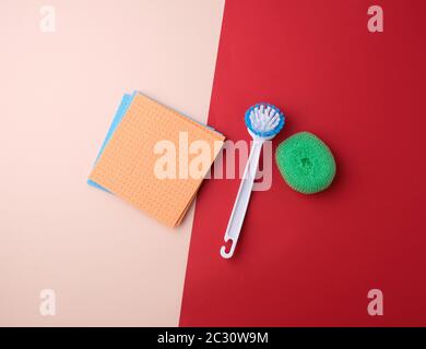 Produkte für Home Reinigung: Bürste, bunte Schwämme für Abstauben auf einem farbigen Hintergrund, Ansicht von oben, flach Stockfoto