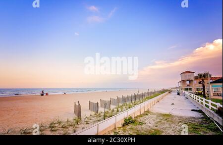 Die Sonne untergeht auf der Ufermauer und Strandfechten auf St. Augustine Beach in St. Johns County Ocean Pier, 14. April 2015, in St. Augustine, Florida. Stockfoto