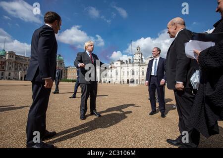 Premierminister Boris Johnson (2. Links) und der französische Präsident Emmanuel Macron (links) mit Außenminister Dominic Raab und dem französischen Außenminister Jean-Yves Le Drian beobachten einen Flipper der roten Pfeile und ihres französischen Gegenstück, La Patrouille de France von Horse Guards Parade in London während seines Besuchs in Großbritannien. Stockfoto