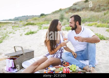 Ein Paar trinkt am Strand beim Picknick Rosenwein Stockfoto