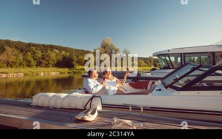 Frau und Mann entspannen sich im Sommer auf ihrer Flussyacht Stockfoto