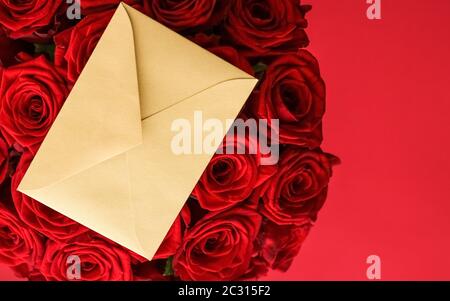 Liebesbrief und Blumenlieferservice am Valentinstag, luxuriöser Strauß roter Rosen und Kartenumschläge auf rotem Hintergrund Stockfoto