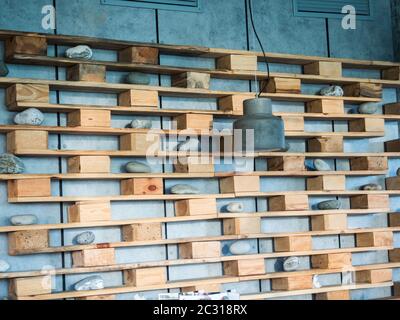 Regal mit Holzregalen an der Wand mit dekorativen Seesteinen Russland in Sotschi Stockfoto