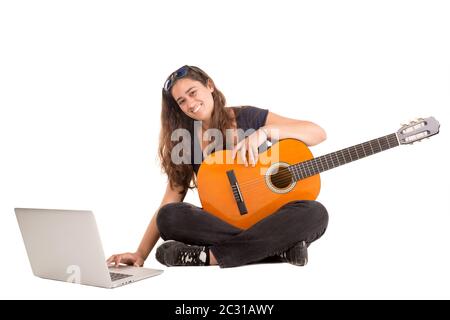 Fröhliches Mädchen posiert mit Gitarre und Laptop, isoliert in Weiß Stockfoto