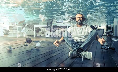 Mann sitzt unter Wasser, das in einem Yoga Position entspannt. Büro komplett überflutet. Konzept der Probleme und der Ruhe. Stockfoto
