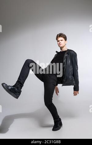 Ganzkörperportrait von jungen fit Mann in dunklen Tüchern auf dem weißen Hintergrund. Junge Männliche Mode Modell Posiert In Casual Outfit. Stockfoto