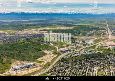 Luftaufnahme der Westseite von Calgary, Alberta Kanada, mit dem Trans-Canada Highway, dem Canada Olympic Park und den Rocky Mountains. Stockfoto