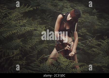 Schöne Frau auf der Jagd im Wald. Kleid aus rotem Fell Stockfoto