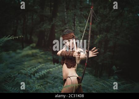 Schöne Jägerin mit Bogen im Wald. Außenportrait Stockfoto