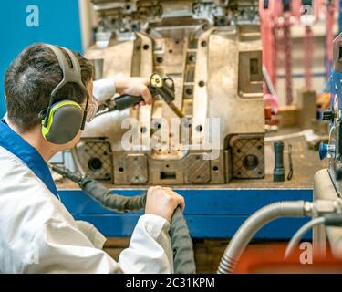 Der Ingenieur führt das Einfrieren des Gussteils mit einer speziellen Maschine durch. Wartung von Metallformen für Kunststoffguss in der Fabrik. Stockfoto