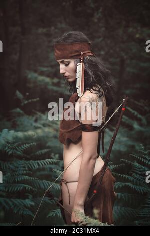 Indische Jägerin im Wald. Pose mit Schleife Stockfoto