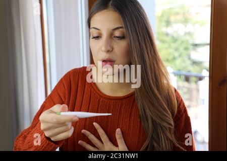 COVID-19 Pandemie Coronavirus Fieber Frau Temperatur-Thermometer prüfen Home Kurzatmigkeit der Atemsymptome SARS-COV-2. Mädchen mit Kurzatmigkeit Stockfoto