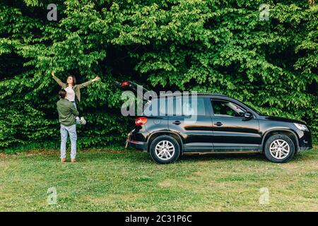 Junges Paar Piggy-Unterstützung Gefühle Zuneigung Leidenschaft Spaß Freizeit in der Nähe Auto im Park Stockfoto