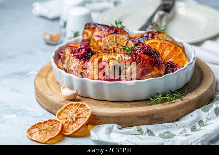 Hähnchenschenkel gebacken mit Orange und Kirsche. Stockfoto