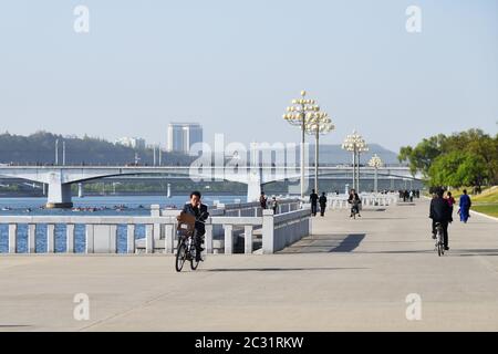 Pjöngjang, Nordkorea - 1. Mai 2019: Ein Mann fährt auf dem Fahrrad entlang des Damms. Fahrrad ist der häufigste private Transport in Pjöngjang Stockfoto