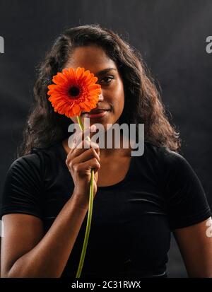 Lächelnde Frau Holding Blume Stockfoto