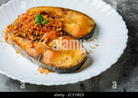 Tiefgebratene Pangasius Fisch mit schwarzem Pfeffer Knoblauch und Fischquelle, schnell und einfach Gericht. Stockfoto