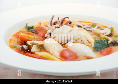 Kalmare und Zitronengras würzige Suppe mit Pilzen, Tomaten und Kräutern Stockfoto